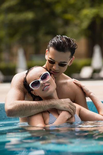 Nivel Superficie Del Hombre Abrazando Mujer Sonriente Gafas Sol Piscina — Foto de Stock