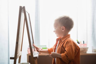 Montessori okulunda sehpanın yanındaki çocuğun yan görünüşü