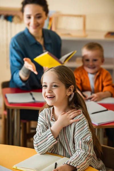 Elmosódott Tanár Rámutat Lányra Aki Mosolyog Osztályteremben Montessori Iskolában — Stock Fotó