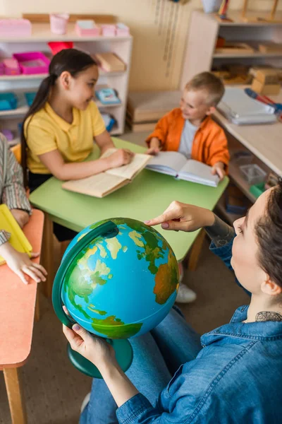 Высокий Угол Зрения Учителя Указывая Глобус Рядом Многонациональными Детьми Время — стоковое фото