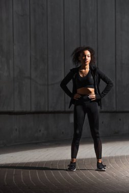 Afro-Amerikan sporcu kadın şehir sokaklarında el ele tutuşuyor. 