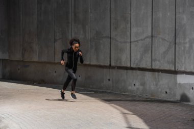 Afrika kökenli Amerikalı koşucu bina yakınında egzersiz yapıyor. 