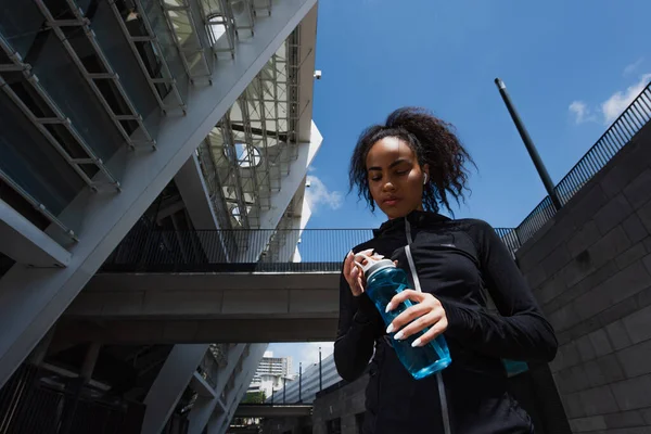 Visão Baixo Ângulo Esportista Afro Americana Olhando Para Garrafa Esportes — Fotografia de Stock