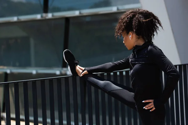 Junge Afrikanisch Amerikanische Sportlerin Wärmt Sich Mit Kopfhörer Nahe Brücke — Stockfoto