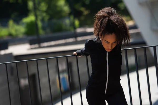 Joven Deportista Afroamericana Escuchando Música Auriculares Calentándose Calle Urbana — Foto de Stock