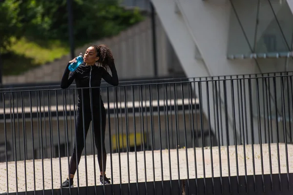 Довольно Африканская Американская Спортсменка Пьет Воду Отдыхая Мосту — стоковое фото