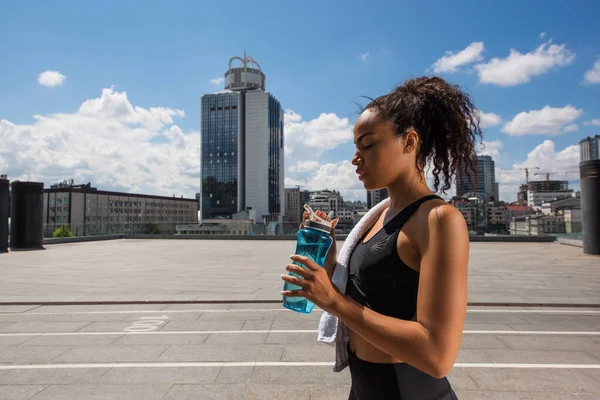 Vista Lateral Deportista Afroamericana Con Toalla Blanca Sosteniendo Botella Deportiva — Foto de Stock