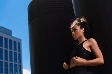 Kulaklıklı Afro-Amerikan sporcusu açık havada evet hareketi gösteriyor. 