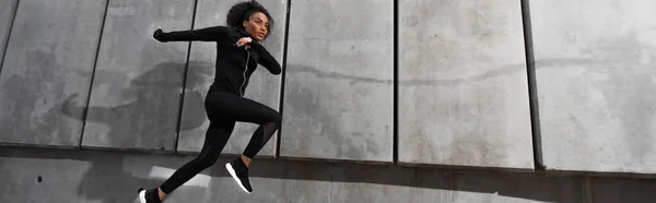 非洲裔美国女运动员在室外建筑物附近奔跑 高举横幅 — 图库照片
