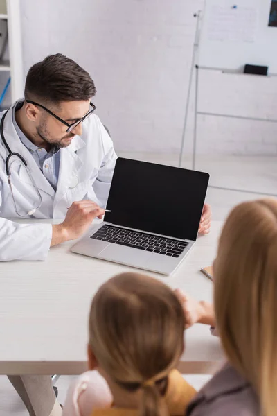 Pediatra Olhando Para Laptop Com Tela Branco Perto Criança Turva — Fotografia de Stock