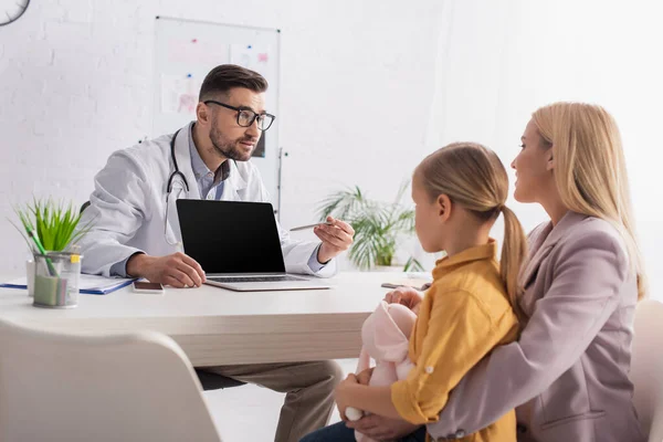 Mother Daughter Looking Family Doctor Pointing Laptop Clinic — Stock Photo, Image
