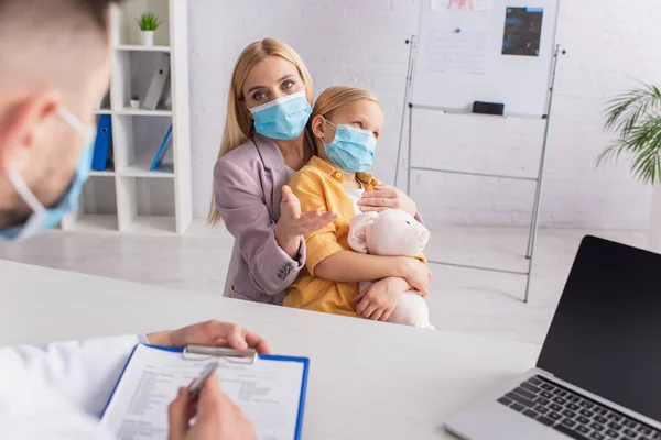 Mother Medical Mask Pointing Pediatrician Child Laptop — Stock Photo, Image