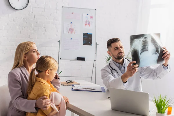 Pediatra Che Guarda Fluorografia Vicino Alla Famiglia Laptop Clinica — Foto Stock