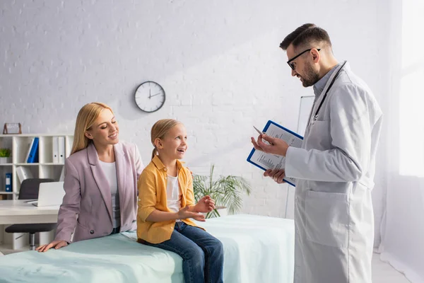 Criança Positiva Conversando Com Médico Perto Mãe Sorridente Clínica — Fotografia de Stock