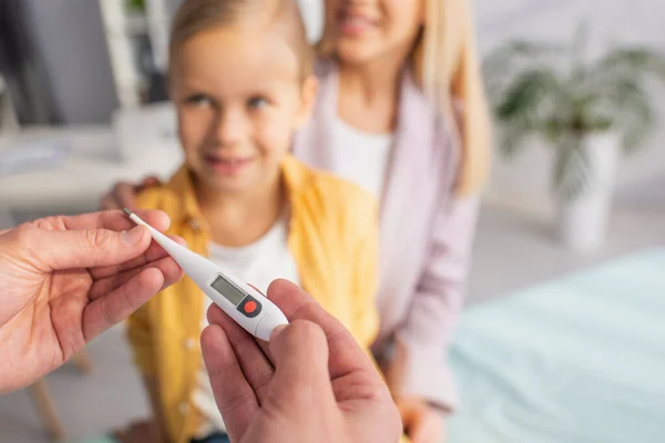 Läkare Som Håller Elektronisk Termometer Nära Suddig Patient Sjukhus — Stockfoto