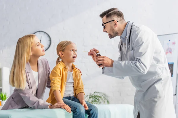 Médico Segurando Xarope Perto Criança Com Boca Aberta Mãe Clínica — Fotografia de Stock