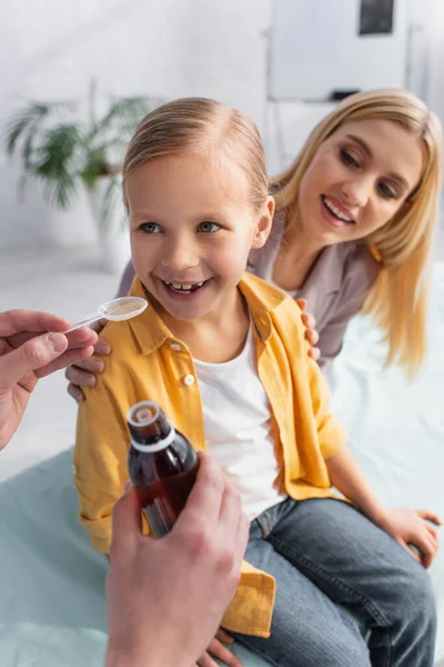 Médico Sosteniendo Cuchara Jarabe Cerca Niño Positivo Madre Sonriente Sobre — Foto de Stock