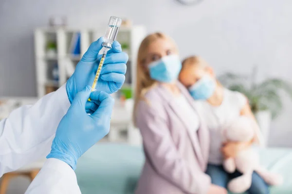 Pediatra Guantes Látex Recogiendo Vacuna Cerca Familia Borrosa Hospital — Foto de Stock