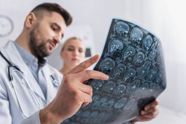 Hastanedeki beyin MR taramasına bakan bulanık doktor ve hasta