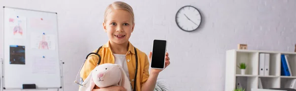 Lachend Meisje Met Speelgoed Bunny Holding Mobiele Telefoon Met Leeg — Stockfoto