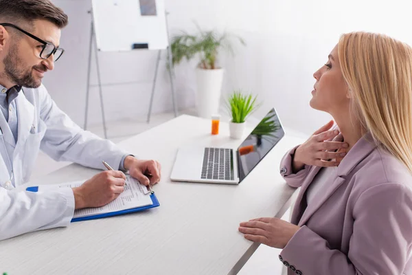 Smiling Doctor Writing Prescription Woman Touching Sore Throat Consultation — Stock Photo, Image