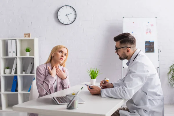 Läkare Skriver Urklipp Medan Tittar Kvinna Röra Ont Halsen Konsultation — Stockfoto