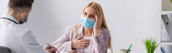 Femme Malade Dans Masque Médical Touchant Tête Poitrine Près Médecin — Photo