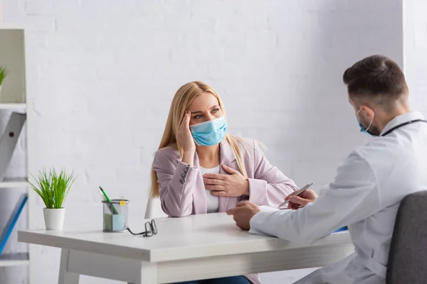 Blonde Woman Protective Mask Suffering Headache Physician — Stock Photo, Image