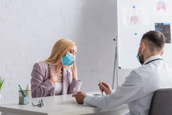 Tıbbi Maskeli Hasta Kadın Doktorun Yanında Öksürüyor Göğsüne Dokunuyor — Stok fotoğraf