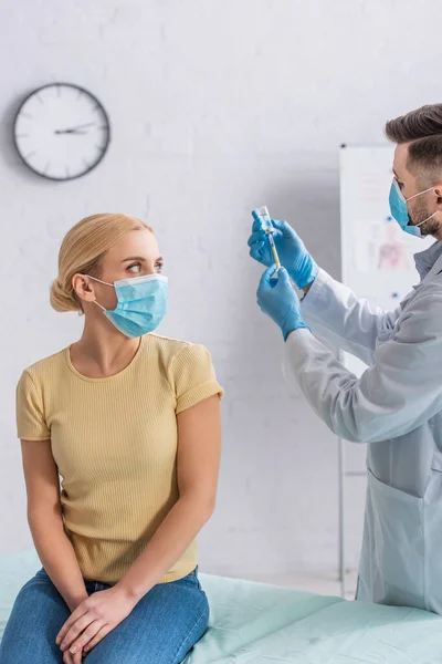 Frau Mit Schutzmaske Blickt Auf Arzt Der Spritze Mit Impfstoff — Stockfoto