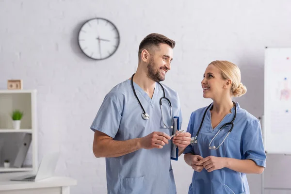 Médicos Felizes Uniforme Azul Olhando Para Outro Enquanto Conversam Hospital — Fotografia de Stock