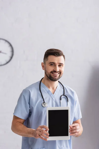 Uśmiechnięty Lekarz Patrzący Kamerę Pokazujący Cyfrowy Tablet Pustym Ekranem — Zdjęcie stockowe