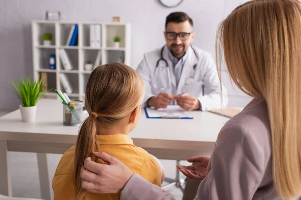 Vista Posterior Chica Con Mamá Cerca Borrosa Pediatra Sonriendo Lugar — Foto de Stock