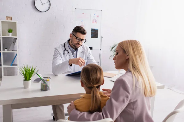 Family Doctor Looking Clipboard Woman Kid Clinic — Stock Photo, Image