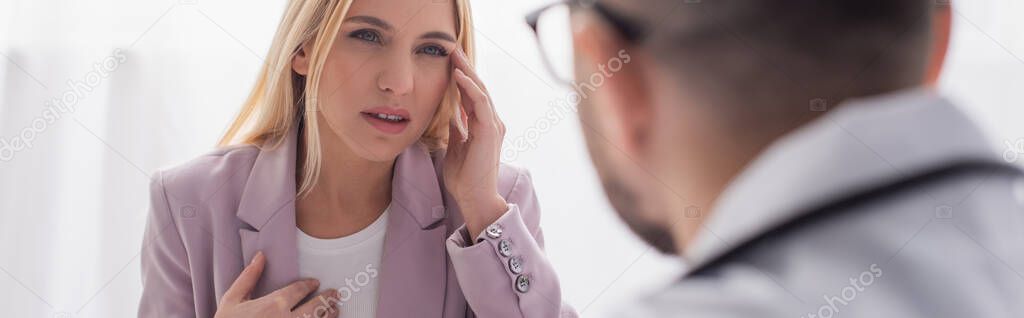 woman feeling bad and touching head during conversation with blurred doctor, banner