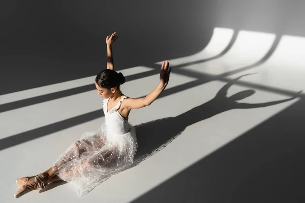 芭蕾舞演员举手表决的侧视图 背景灰暗 阳光直射 — 图库照片