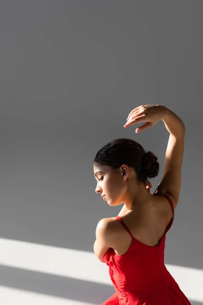Zijaanzicht Van Klassieke Danser Rode Jurk Grijze Achtergrond Met Zonlicht — Stockfoto