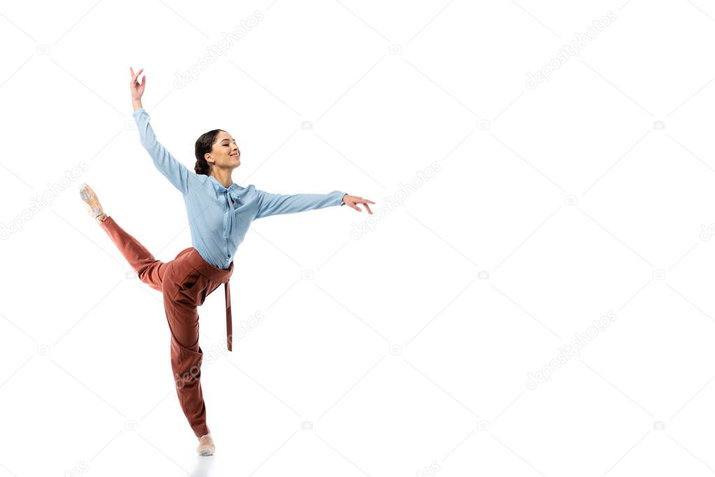 Cheerful professional ballerina dancing on white background 