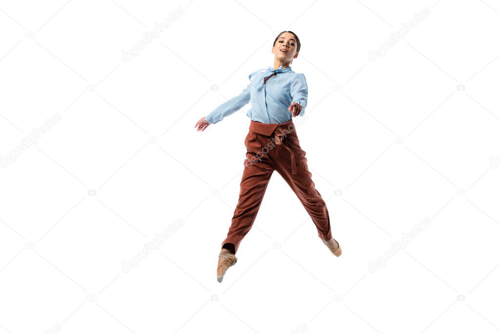 Smiling ballerina looking at camera while jumping isolated on white 
