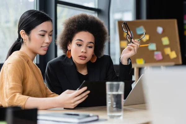 Interracial Affärskvinnor Tittar Urklipp Medan Arbetar Kontoret — Stockfoto