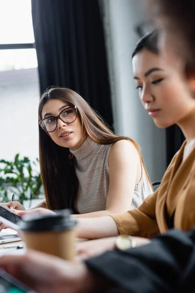 Brunette Woman Eyeglasses Talking Interracial Business Partners Blurred Foreground — Stock Photo, Image