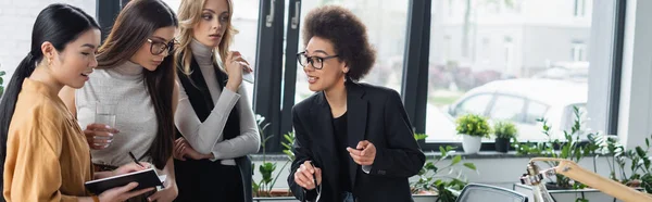 African American Businesswoman Pointing Finger Colleagues Asian Manager Writing Notebook — Stock Photo, Image