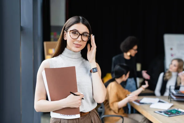 Lächelnde Geschäftsfrau Mit Dokumenten Die Eine Brille Der Nähe Verschwommener — Stockfoto