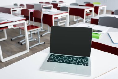 laptop with blank screen on desk in modern school clipart