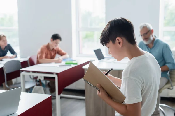 Asiatisk Skolpojke Med Anteckningsbok Stående Klassrummet — Stockfoto