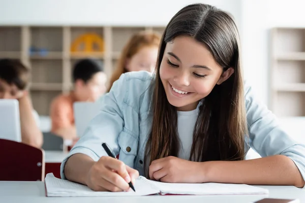 Smiling Schoolgirl Writing Notebook Classroom — 스톡 사진