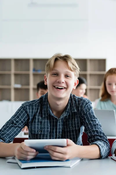 Happy Uczennica Gospodarstwa Cyfrowe Tablet Patrząc Aparat Fotograficzny Klasie — Zdjęcie stockowe