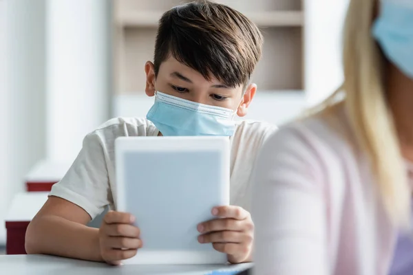 Aziatisch Schooljongen Medisch Masker Met Behulp Van Digitale Tablet Klas — Stockfoto