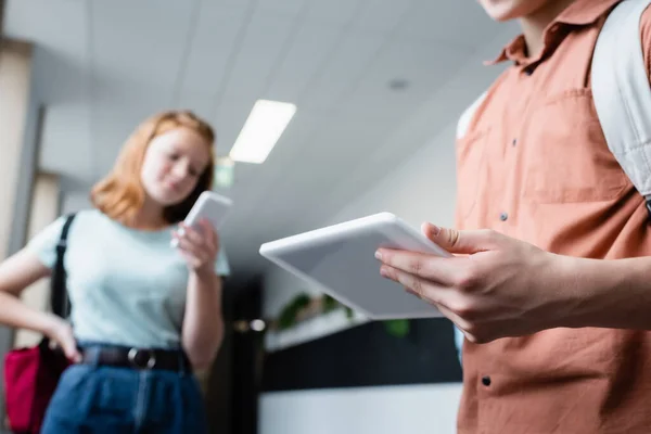 Teenage Boy Using Digital Tablet Blurred Girl Smartphone School Corridor — Stock Photo, Image