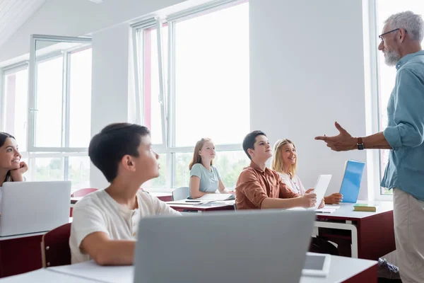 Multicultural Teenage Pupils Listening Middle Aged Teacher Talking Lesson — 스톡 사진